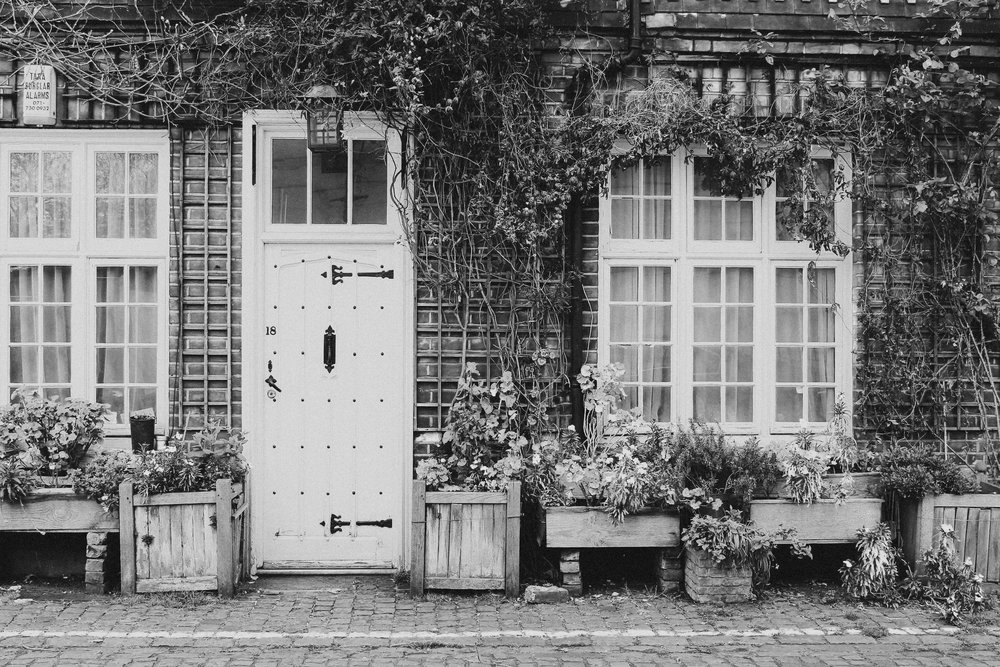 Black and white of front of a house with plants growing