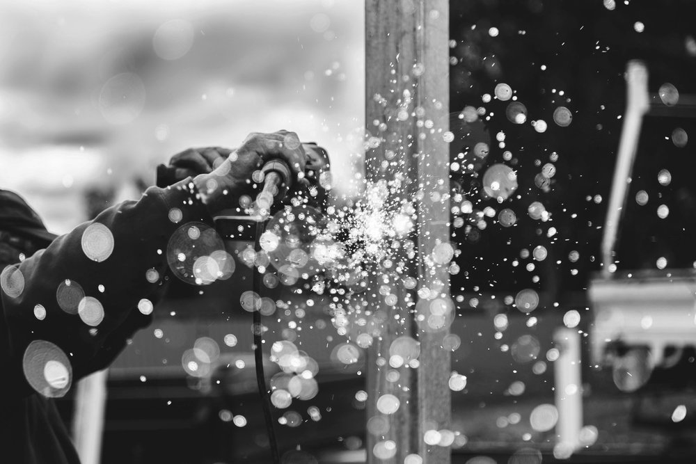 Black and white of a man with welder and sparks