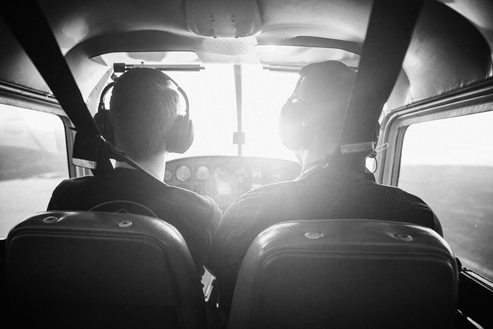 Black and white of two men in cockpit of an airplane