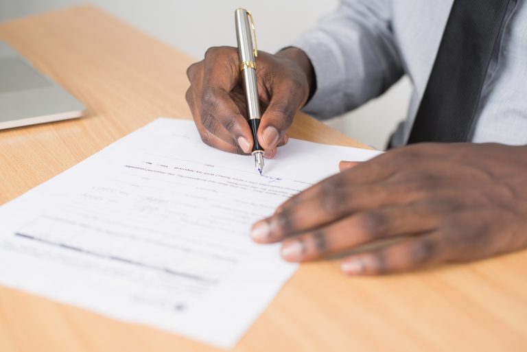 Image of man signing a form